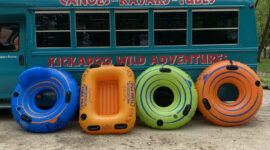River tube rentals leaning against shuttle bus at Kickapoo Wild Adventures
